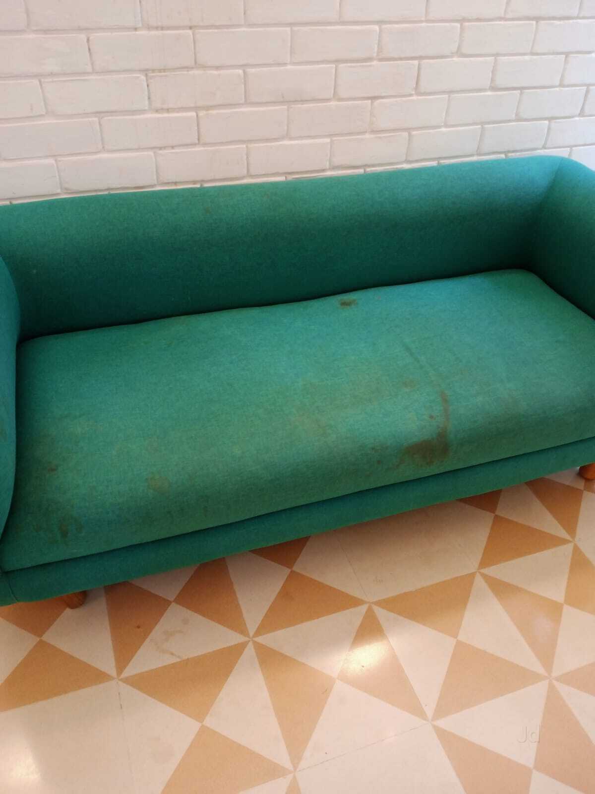 Stained green fabric sofa before shampooing